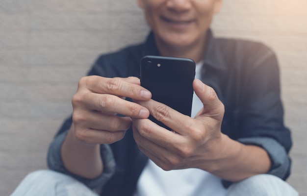 Hombre sonriente asiático videollamadas a través de teléfonos inteligentes móviles, de cerca