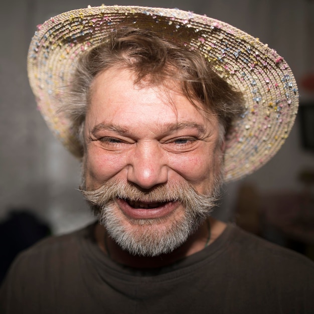 Un hombre sonriente con barba y sombrero es feliz bajo el sol