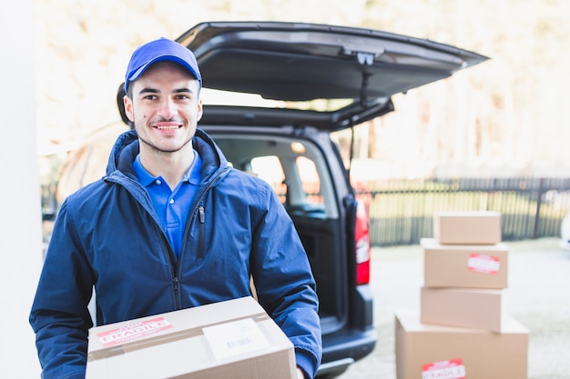 Foto hombre sonriente con caja de cartón