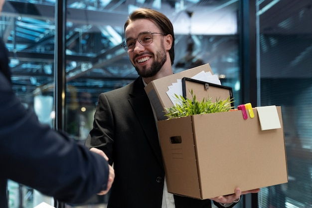 Foto hombre sonriente con caja de cartón