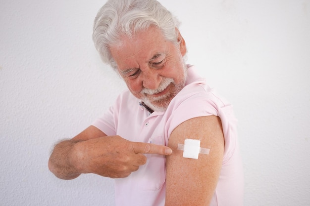 Hombre sonriente caucásico de 70 años después de recibir la dosis de refuerzo de la vacuna contra el coronavirus covid19 concepto de responsabilidad de protección y atención médica