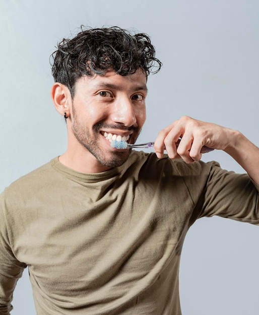 Hombre sonriente cepillándose los dientes aislado Cara de hombre guapo cepillándose los dientes Concepto de cuidado y cepillado de dientes Cara de chico cepillando los dientes aislado Concepto de sonrisa oral y dental