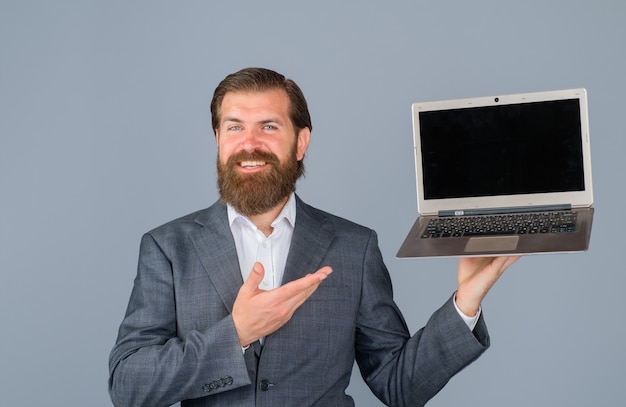 Hombre sonriente con computadora portátil en la oficina hombre de negocios con computadora en la tecnología del lugar de trabajo