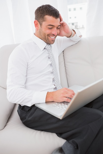 Hombre sonriente en una computadora portátil