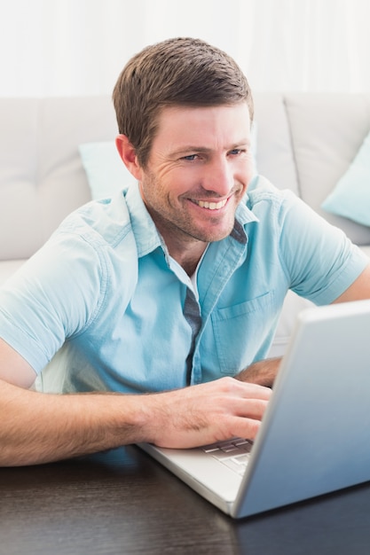 Hombre sonriente en una computadora portátil