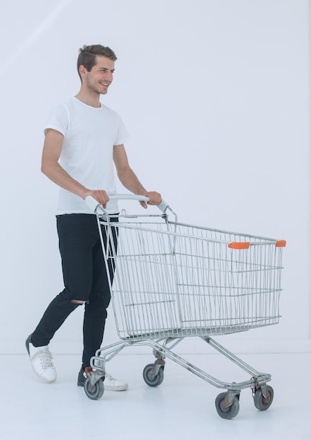 Hombre sonriente empujando carrito de compras