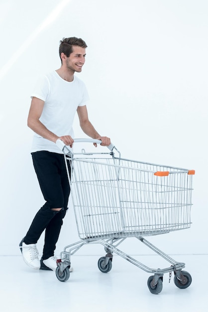 Hombre sonriente empujando la foto del carrito de compras con espacio de copia