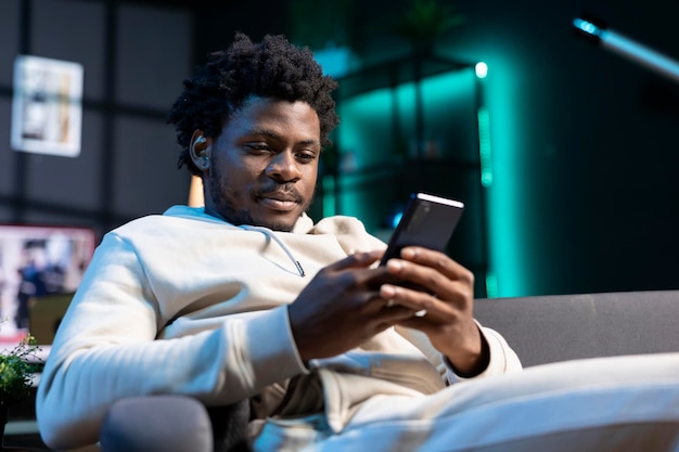Hombre sonriente enviando mensajes de texto impacientemente a un amigo planeando una hora de reunión juntos