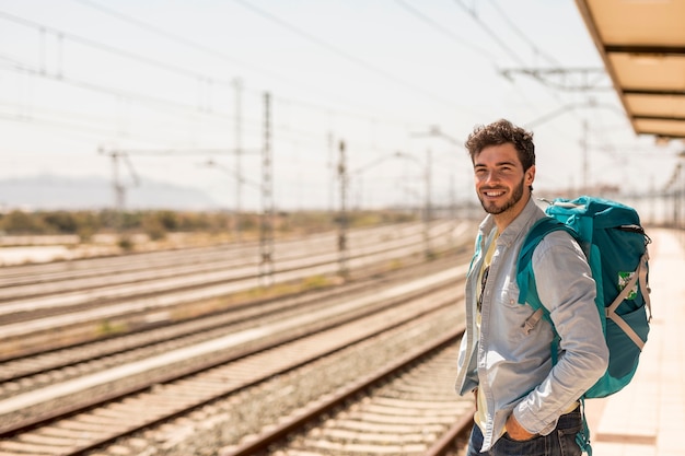 Foto hombre sonriente esperando el tren