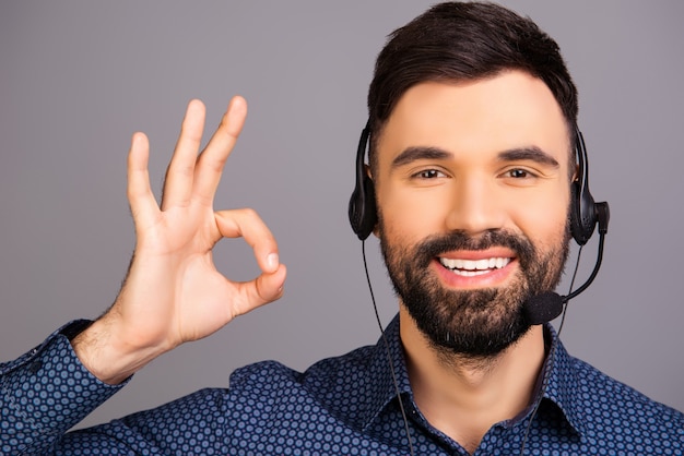 Hombre sonriente feliz en auriculares gesticulando