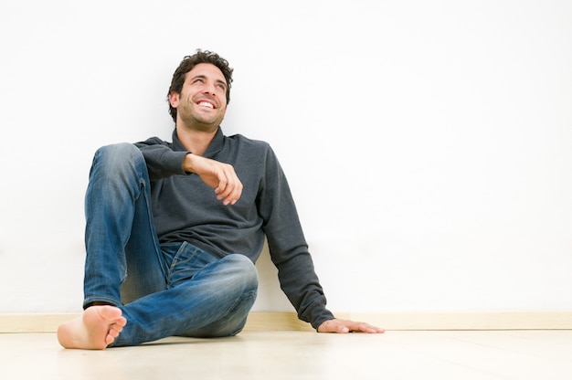 Hombre sonriente feliz mirando hacia arriba y soñando con su futuro