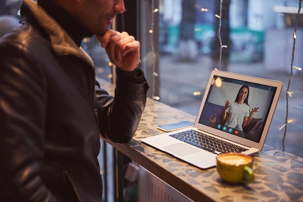 Hombre sonriente hablando con novia por video