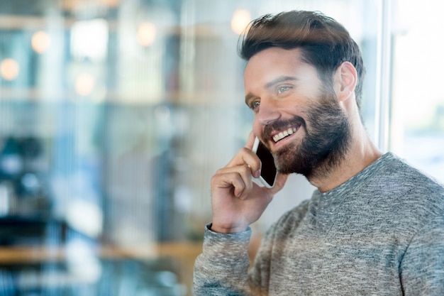 Hombre sonriente hablando por teléfono móvil