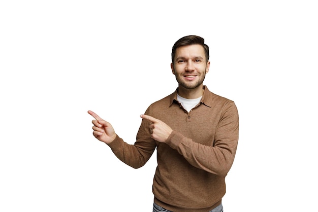 Hombre sonriente hace gestos con las manos para indicar la dirección mientras lleva un suéter marrón en el interior