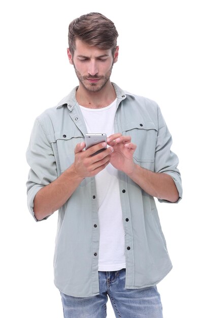 Hombre sonriente leyendo un SMS en el smartphone aislado sobre fondo blanco.