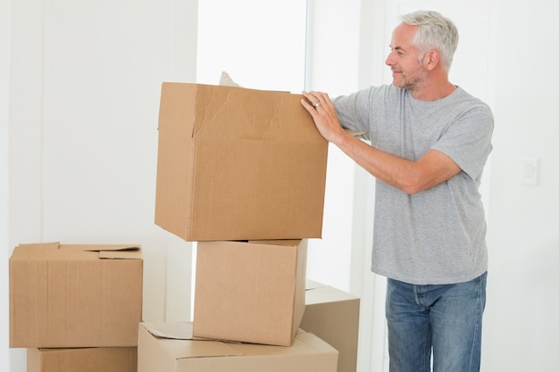 Foto hombre sonriente mirando cajas de cartón en movimiento