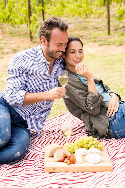 Hombre sonriente con mujer con copa de vino