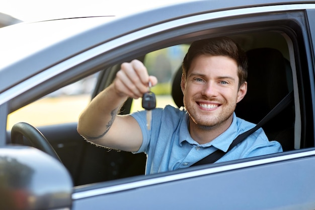 hombre sonriente o conductor con llave sentado en el coche