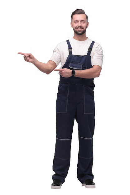 Hombre sonriente en overol apuntando a una copia del espacio