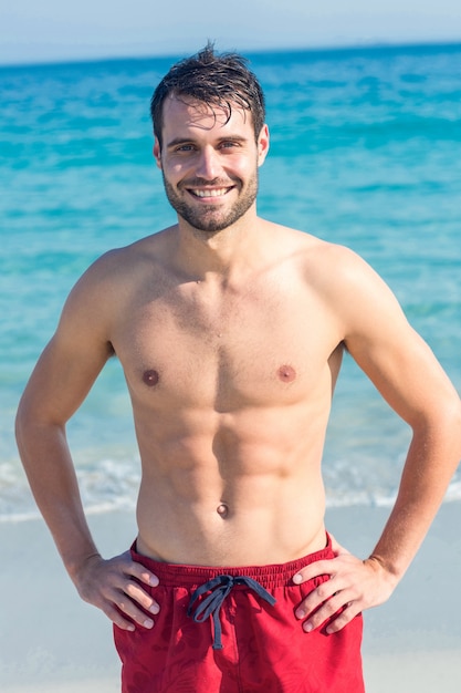 Hombre sonriente en la playa mirando a la cámara