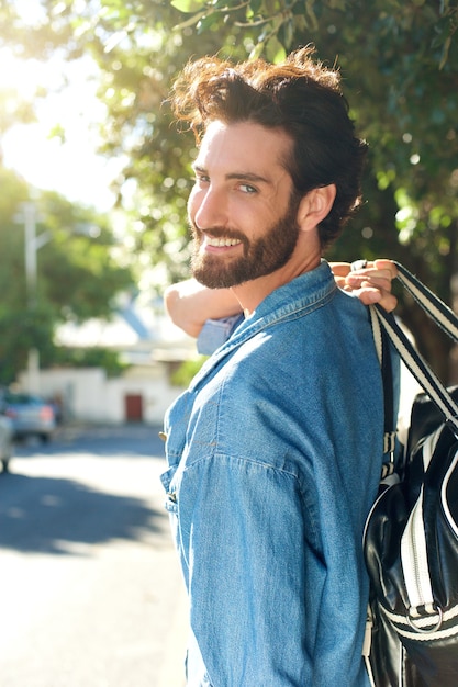 Hombre sonriente que se va con el bolso