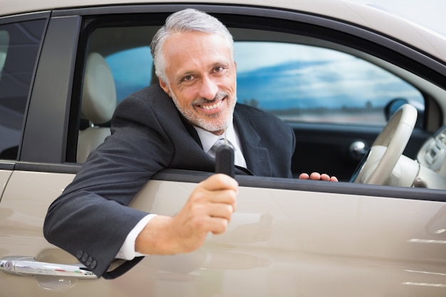 Hombre sonriente que sostiene las llaves del coche