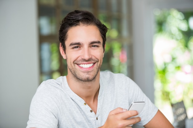 Hombre sonriente que sostiene smartphone