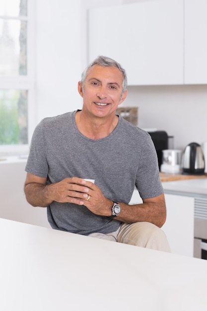 Hombre sonriente que sostiene una taza