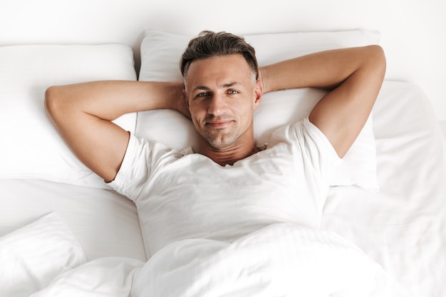 Foto hombre sonriente, relajante, en cama