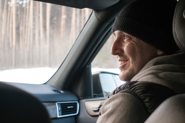 Hombre sonriente en ropa interior dentro del coche