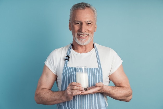 Hombre sonriente sosteniendo un vaso de leche