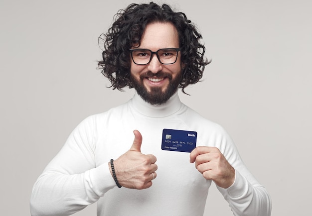 Hombre sonriente con tarjeta de plástico en estudio