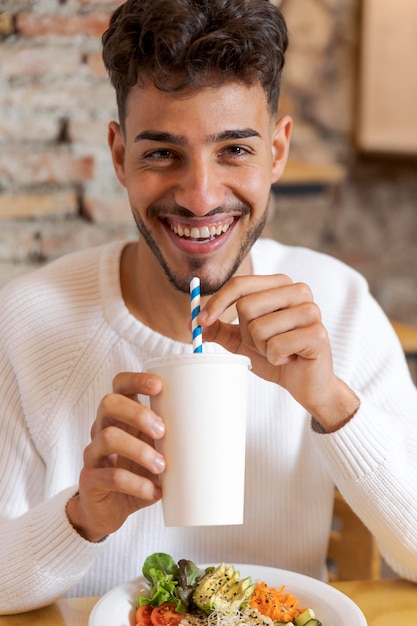 Un hombre sonriente con una taza en la mano.