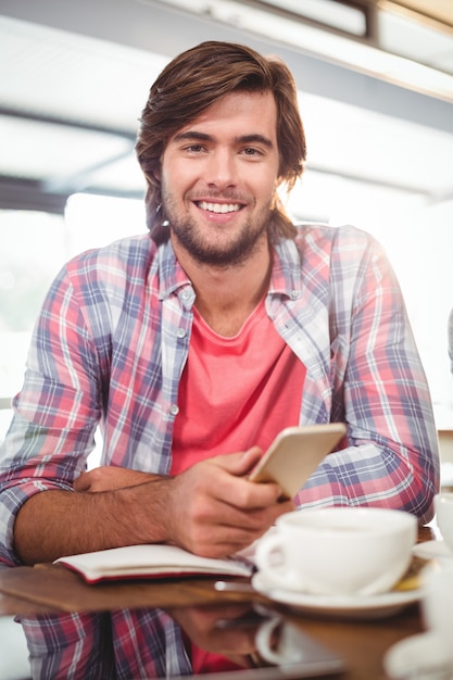 hombre sonriente mediante teléfono móvil