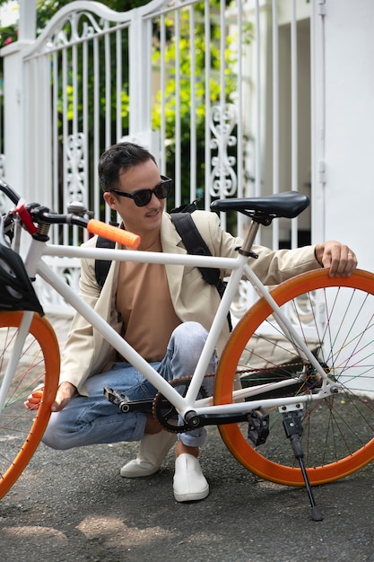 Foto hombre sonriente de tiro completo con bicicleta