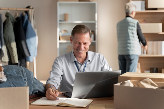 Foto hombre sonriente de tiro medio con laptop