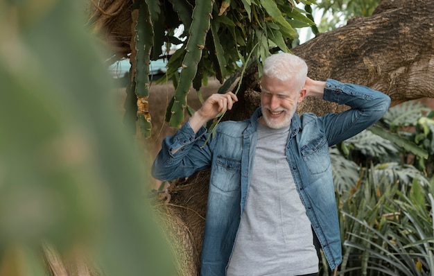 Foto hombre sonriente de tiro medio posando en la naturaleza