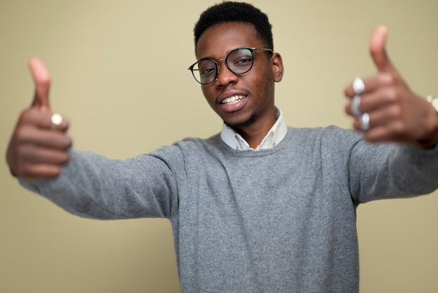 Foto hombre sonriente de tiro medio con los pulgares hacia arriba