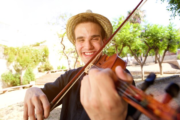 Hombre sonriente tocando una canción en el violín