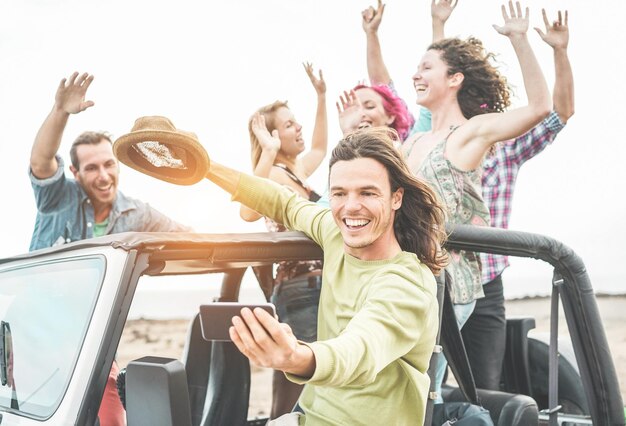 Foto hombre sonriente tomando una selfie con amigos en el coche