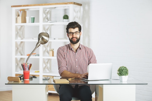 Hombre sonriente usando laptop