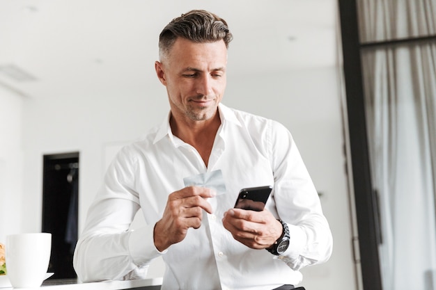 Hombre sonriente vestido con ropa formal tomando café