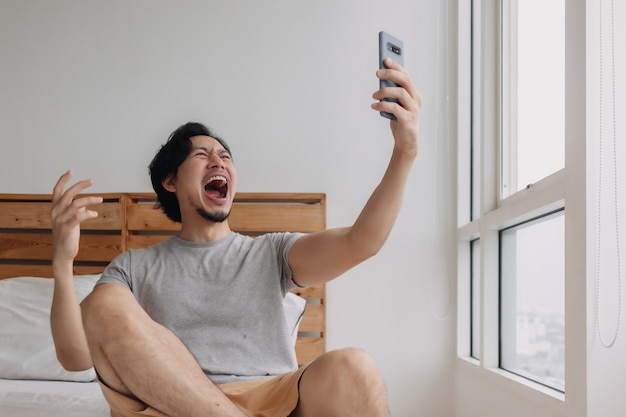 Hombre sorprendido y feliz recibe buenas noticias desde el teléfono inteligente