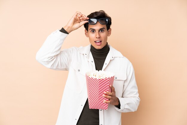 Hombre sorprendido con gafas 3d y sosteniendo un gran cubo de palomitas de maíz