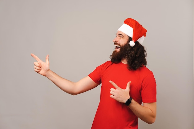 El hombre sorprendido señala con ambas manos y mira a un lado la oferta de Navidad