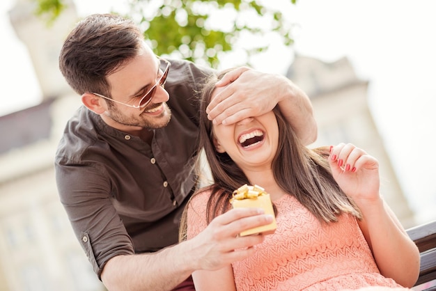 Hombre sorprendiendo a una mujer con un regalo