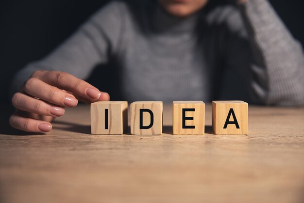 hombre sosteniendo un bloque de cubo de madera con IDEAS