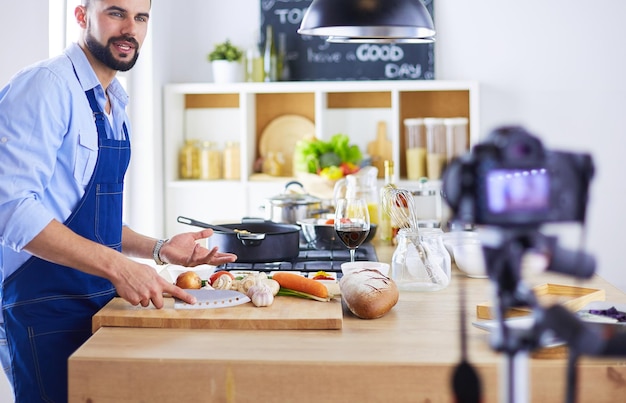 Hombre sosteniendo una bolsa de papel llena de comestibles en el fondo de la cocina Concepto de compras y comida saludable