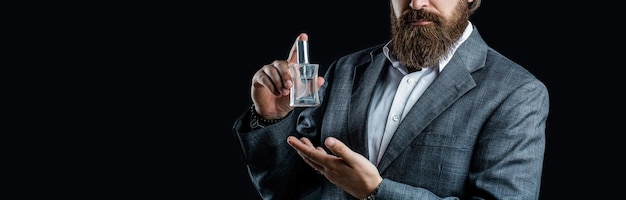 Hombre sosteniendo una botella de perfume Fragancia de perfume de hombre Perfume masculino hombre barbudo en un traje