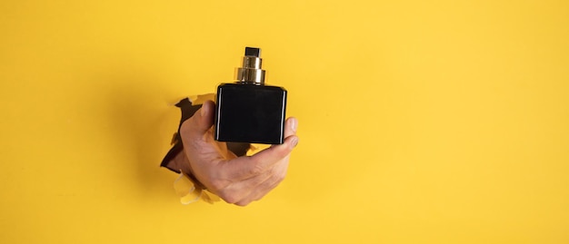 Hombre sosteniendo una botella de perfume